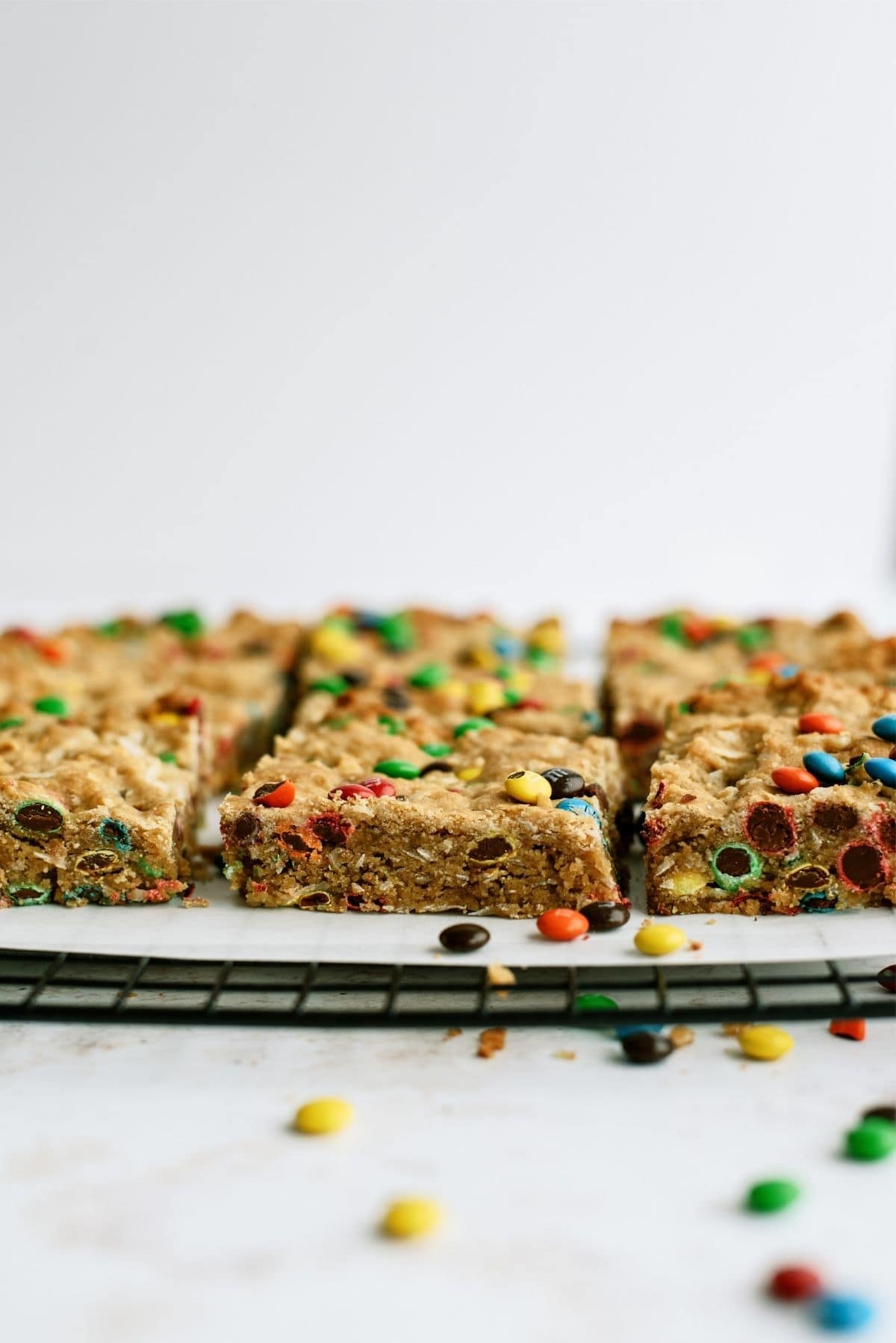 Side view of M&M Samoa Blondies cut into squares on a cooling rack.