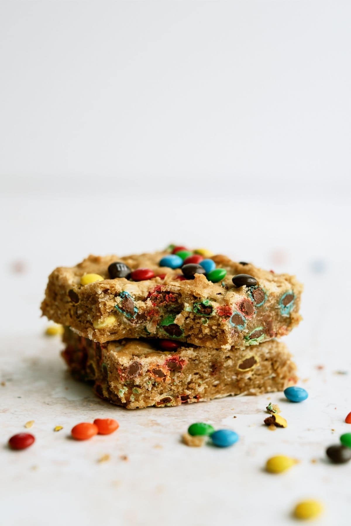 2 M&M Samoa Blondies stacked with the top one missing a bite.