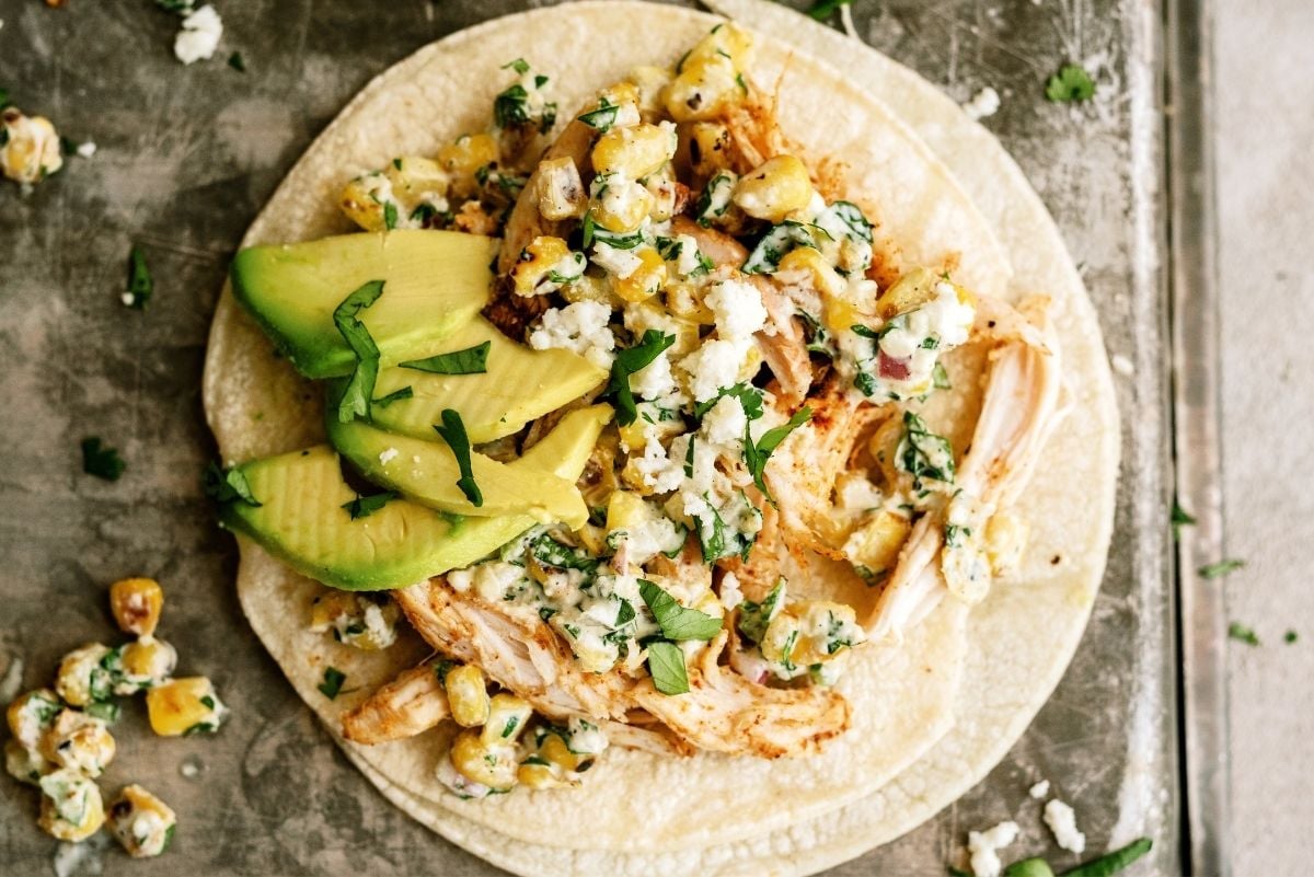 Mexican Street Corn Chicken Taco on a baking sheet with toppings
