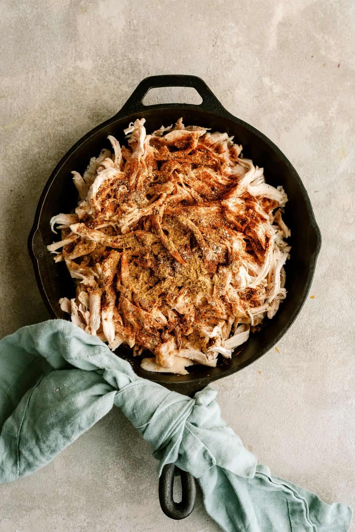 Shredded chicken with seasonings in skillet