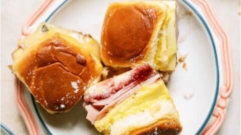 A plate with 3 Monte Cristo Slider Sandwiches with one turned on it's side.