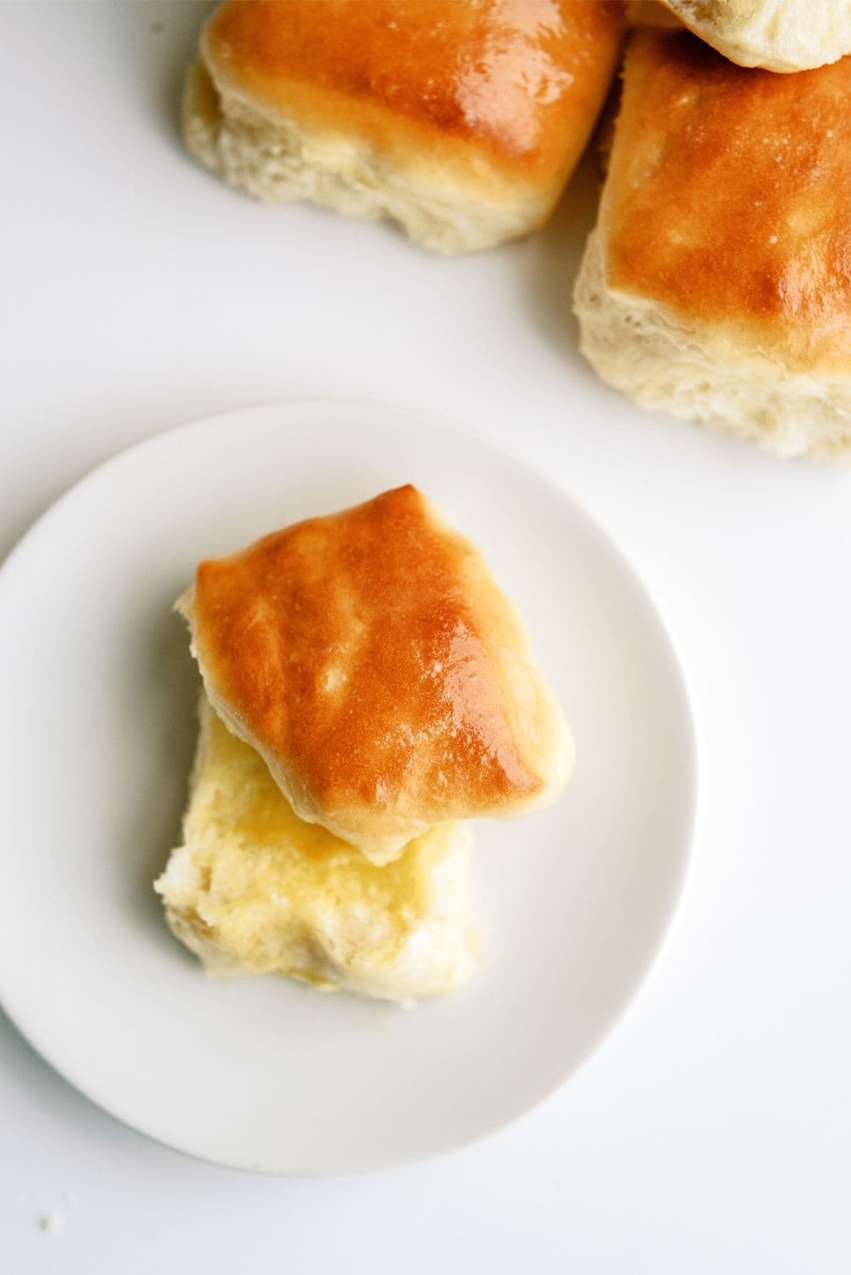 Texas Roadhouse Rolls Copycat on a plate with butter spread on it