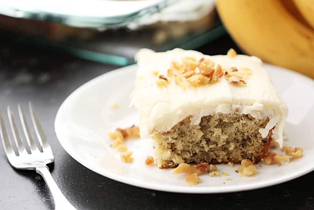 A slice of Frosted Banana Cake on a plate