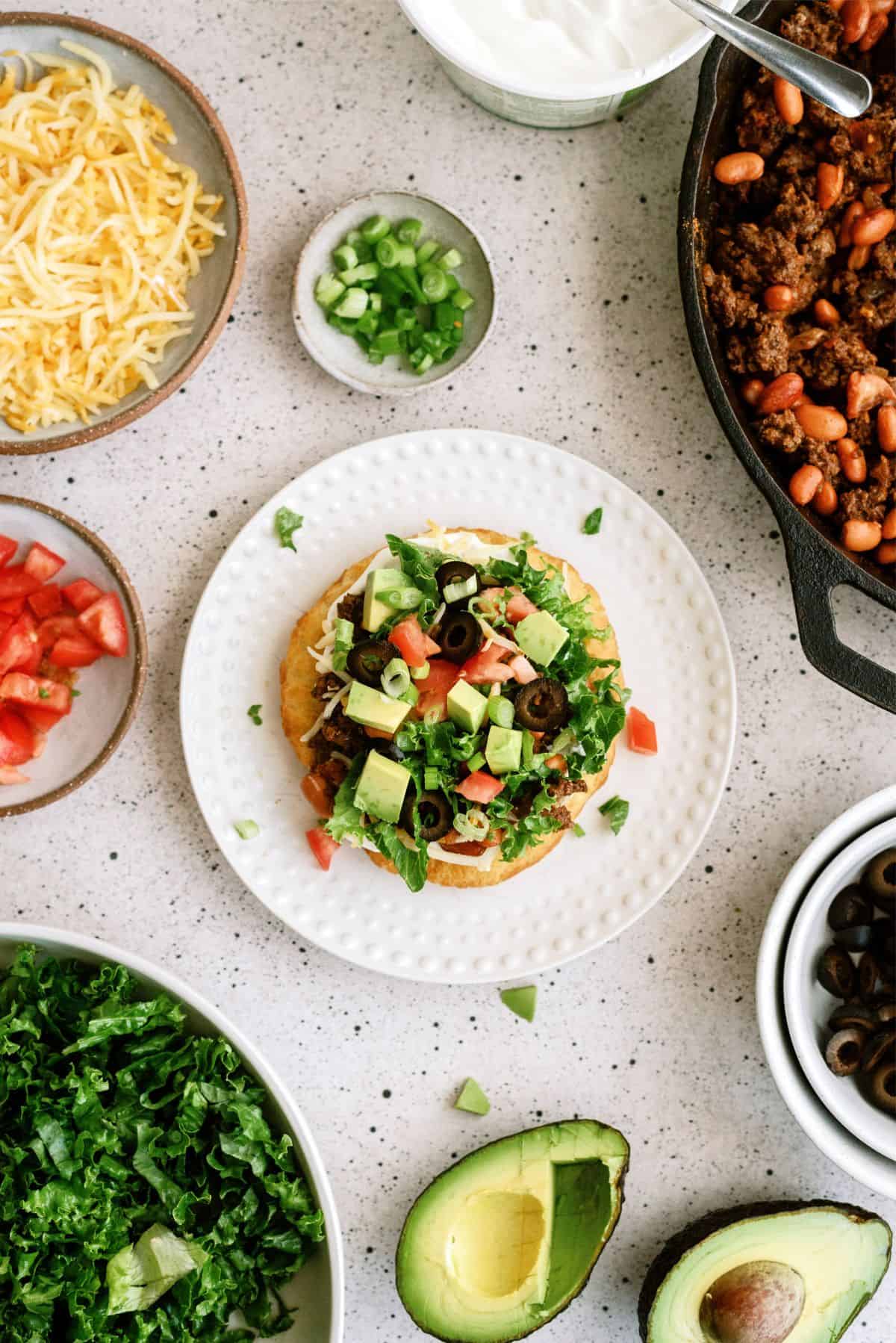 Air Fryer Indian Fry Bread Recipe (Navajo Tacos) on a plate surrounded by toppings