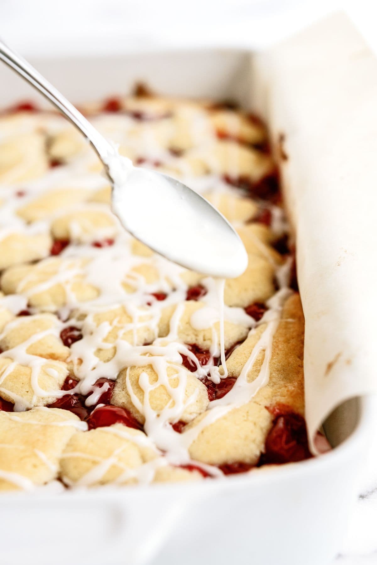 Drizzled icing on top of baked Cherry Pie Bars