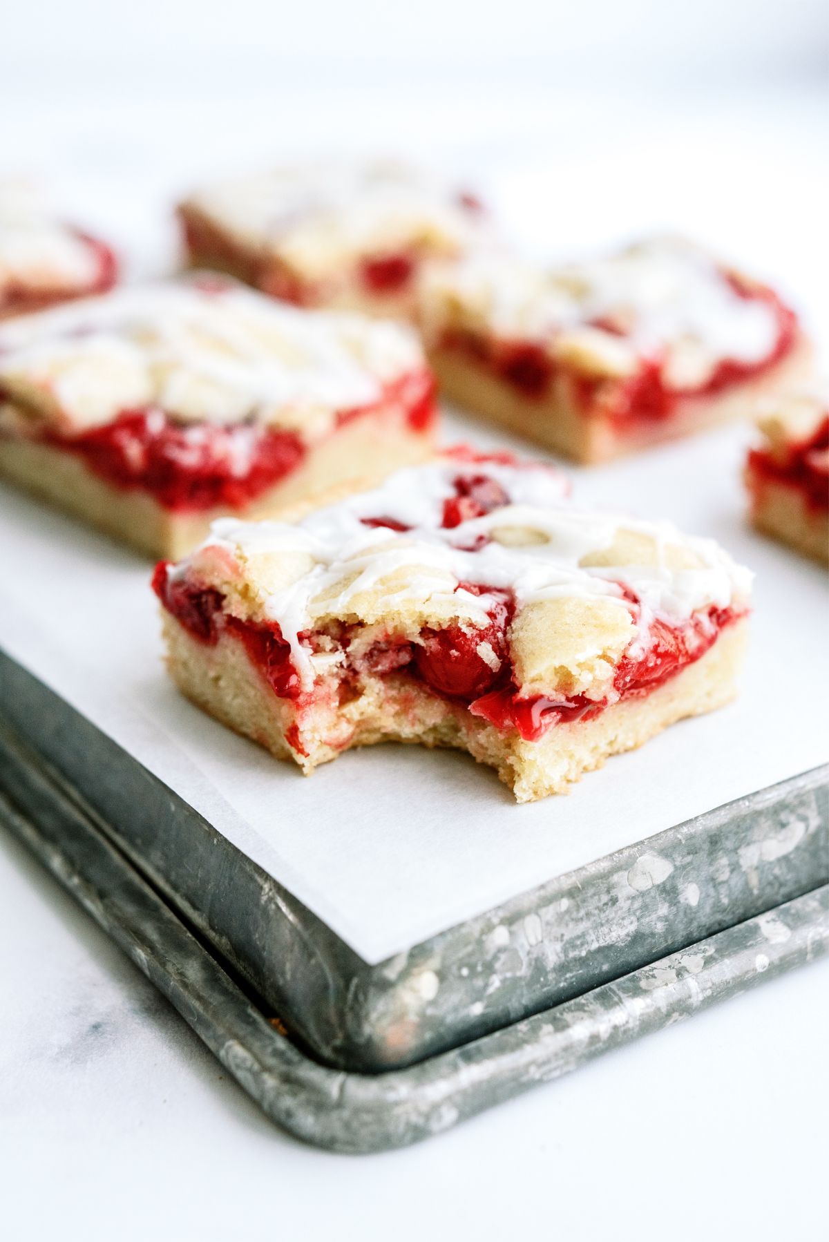 Cherry Pie Bars cut into squares with a bite missing from one bar