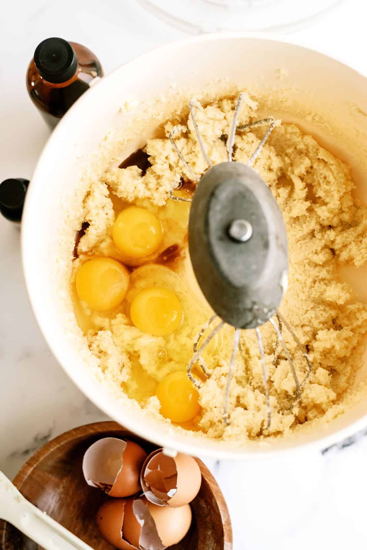 Eggs added into the mixing bowl with sugar and butter