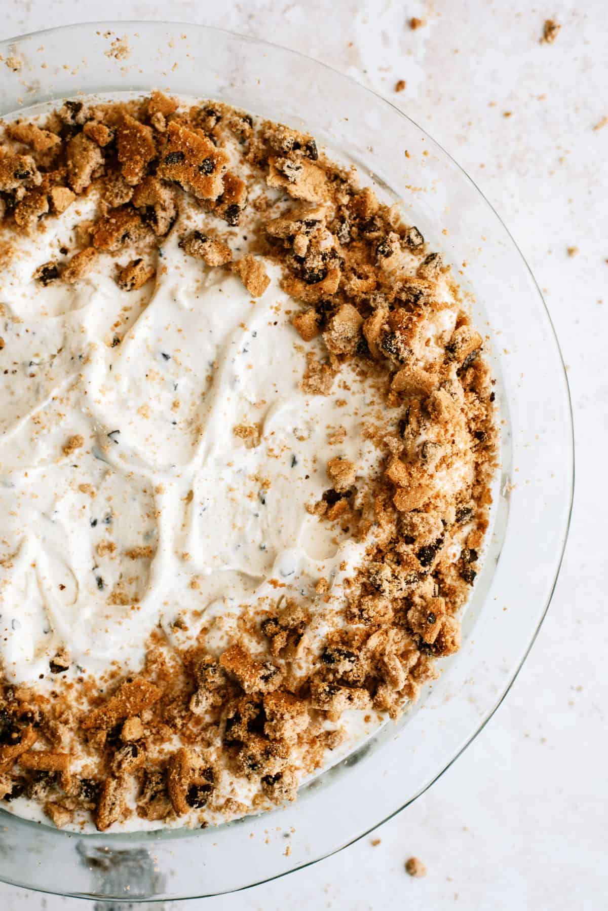 Chocolate Chip Cookie Ice Cream Pie in pie dish with crumbled cookies around the edges.