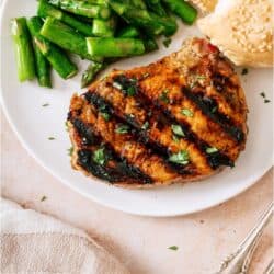 Top view of Grilled Pork Medallions on a plate with asparagus and biscuits.