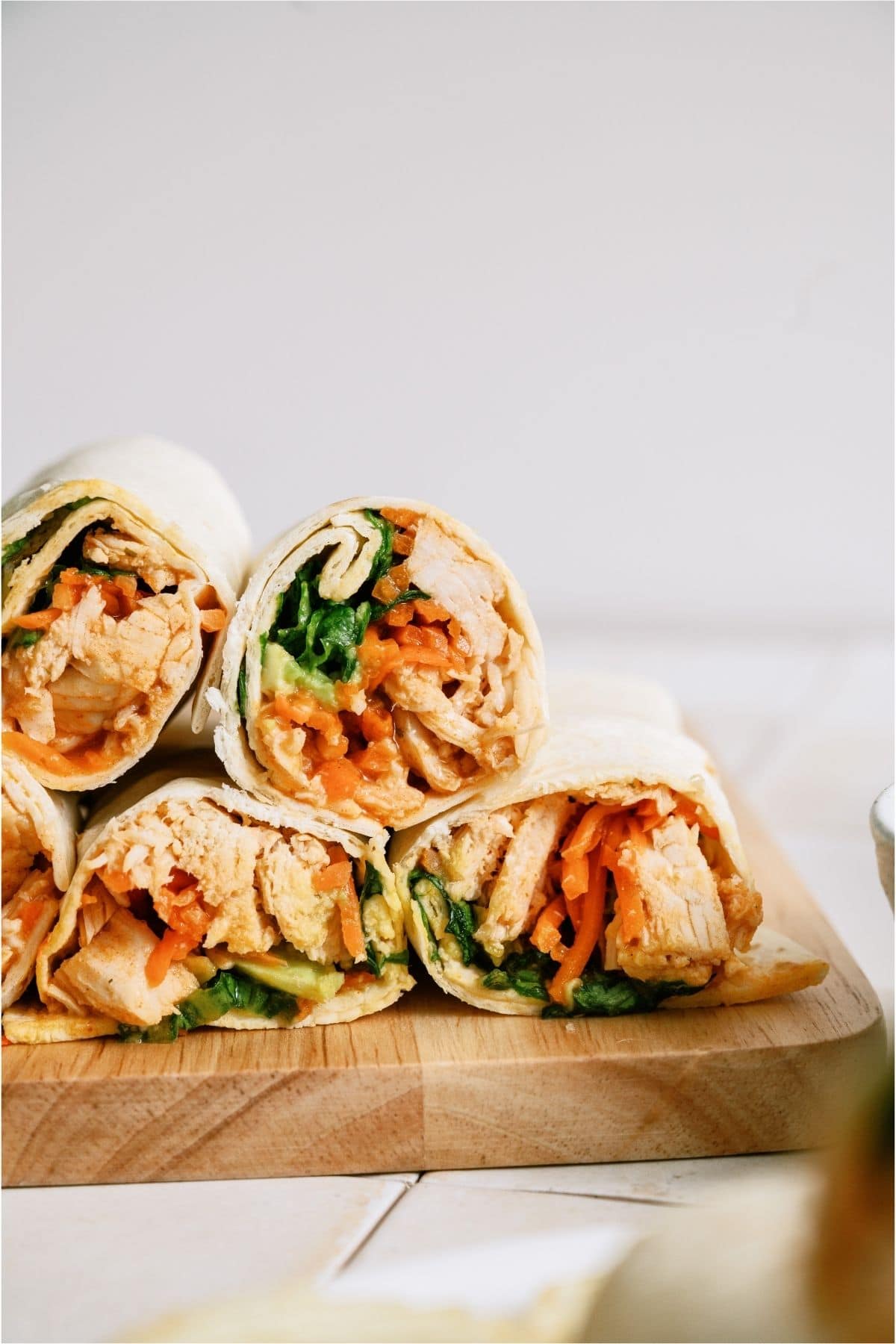 Instant Pot Buffalo Chicken Wraps stacked on a cutting board.