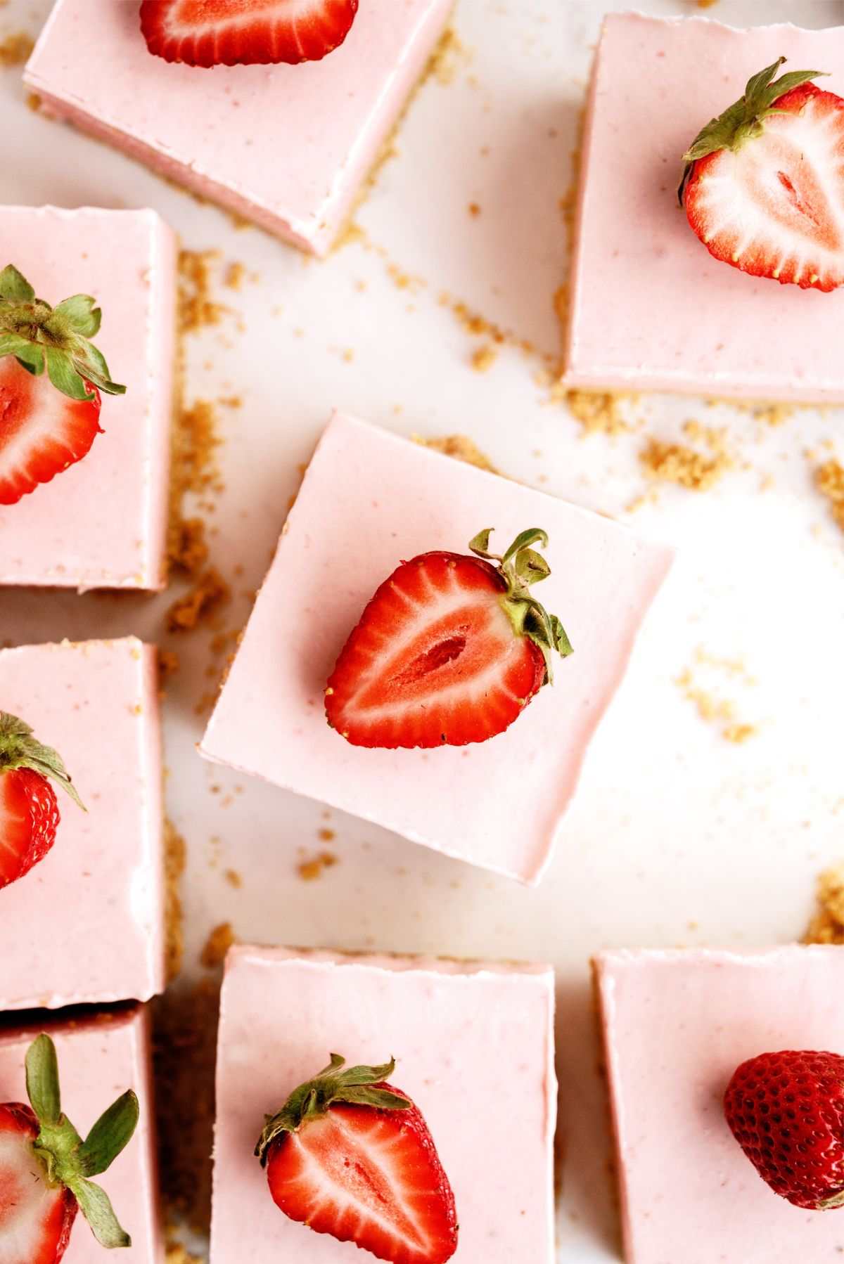 No Bake Strawberry Cheesecake Bars cut into squares and topped with fresh strawberries
