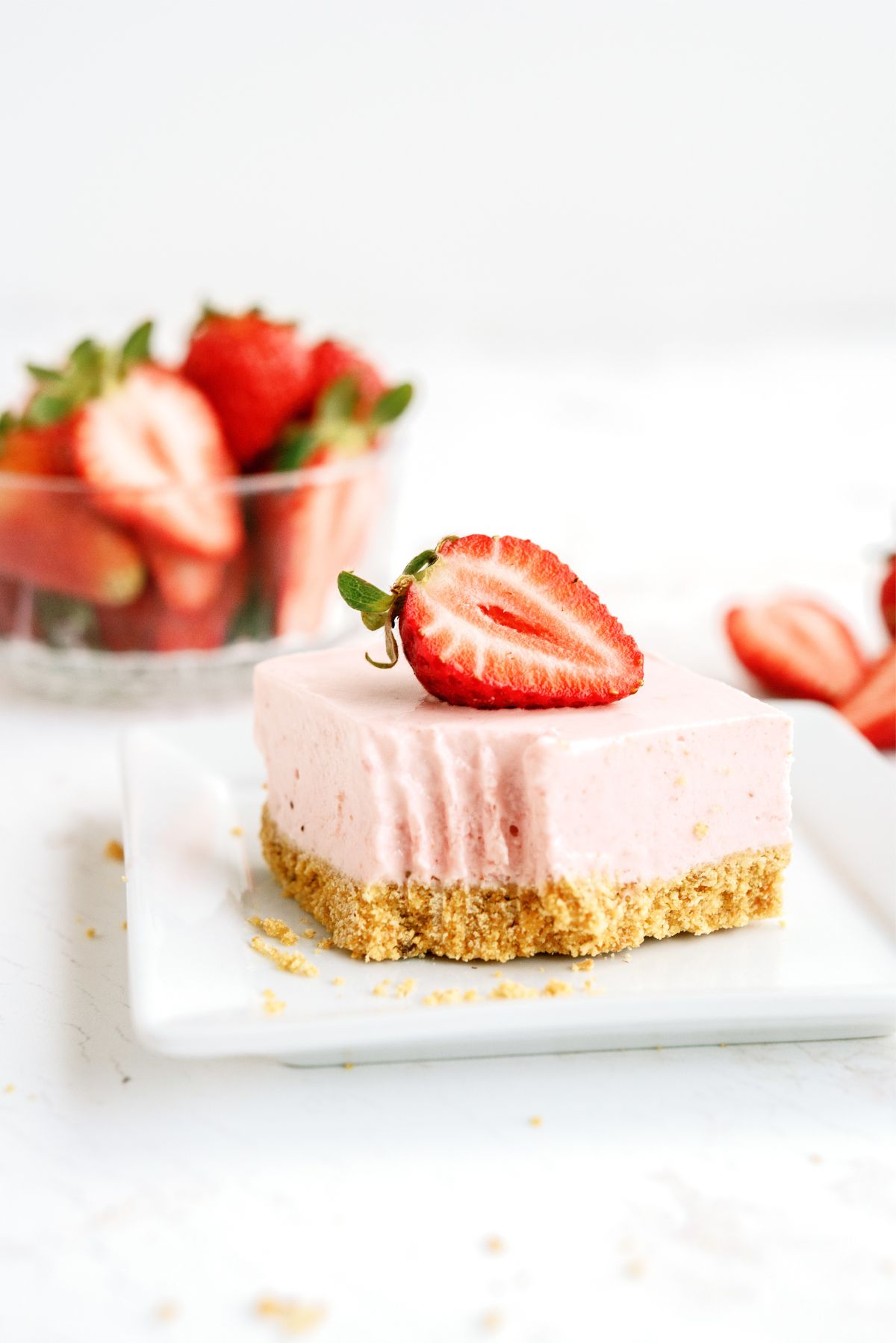 No Bake Strawberry Cheesecake Bar on a plate with a bite missing