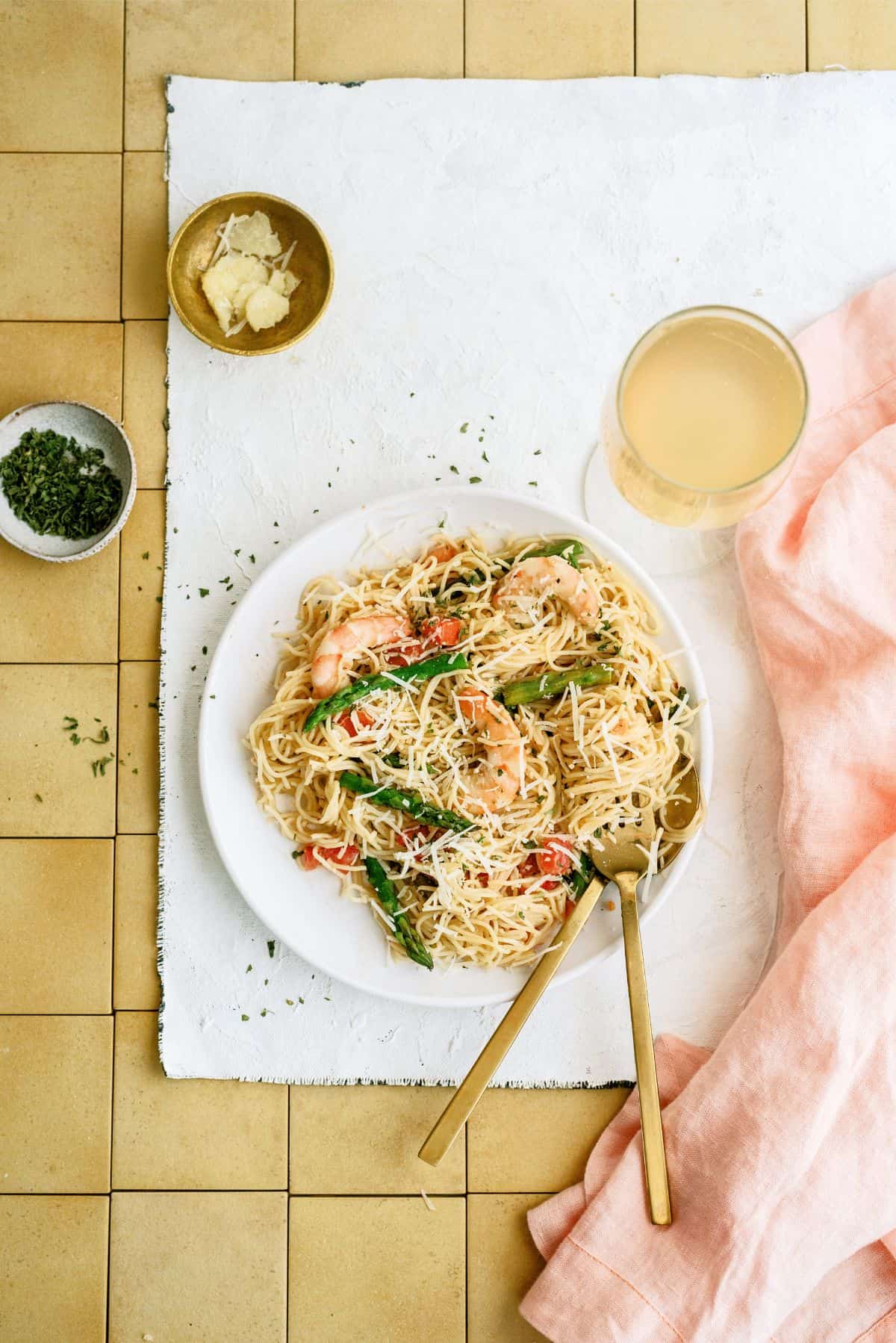 Olive Garden Shrimp Scampi Copycat on a plate with utensils surrounded by ingredients