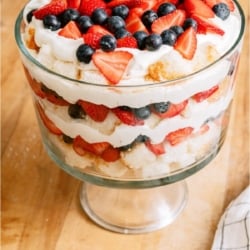 Patriotic Berry Trifle in trifle dish on a wooden countertop.