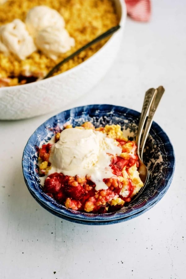 Cherry Cheesecake Dump Cake in a bowl topped with ice cream