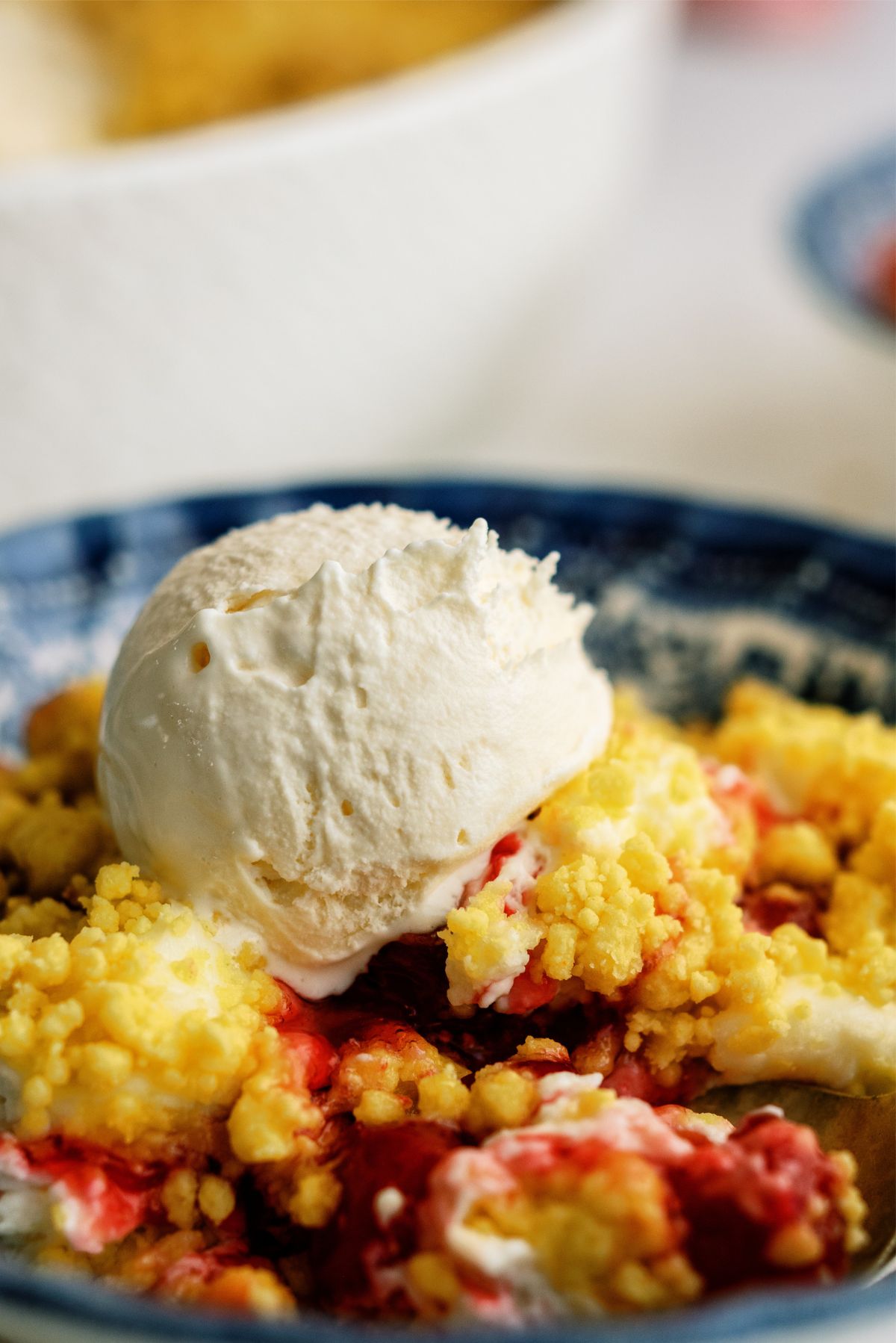 Close up of Cherry Cheesecake Dump Cake Recipe (4 Ingredients) in a bowl topped with ice cream