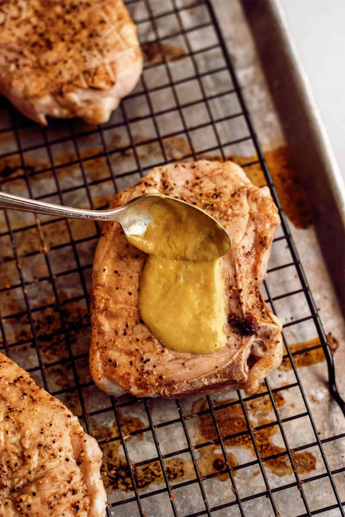 Spooning Honey Mustard sauce on top of pork chops