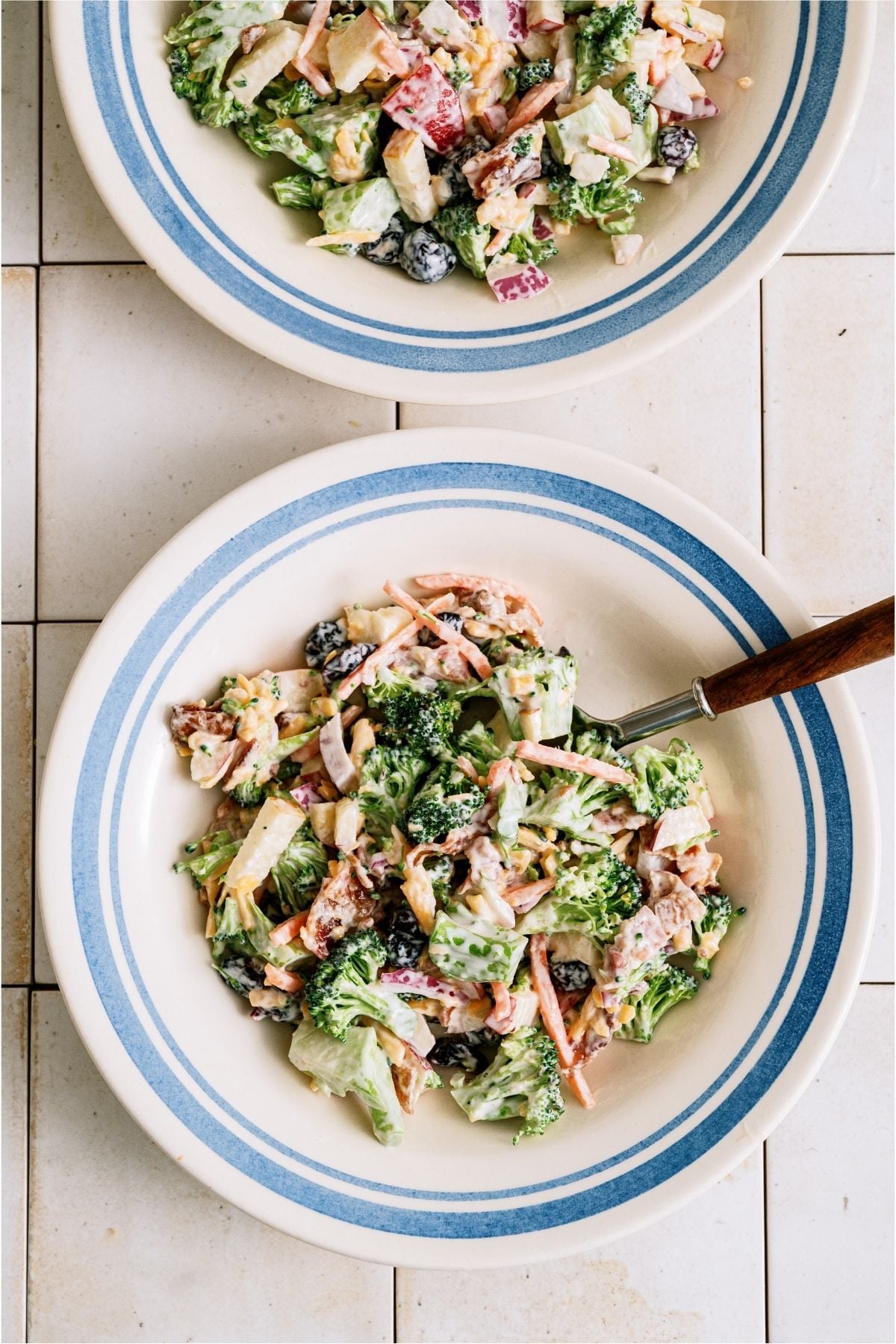 2 white bowls with servings of Loaded Broccoli Salad in them.