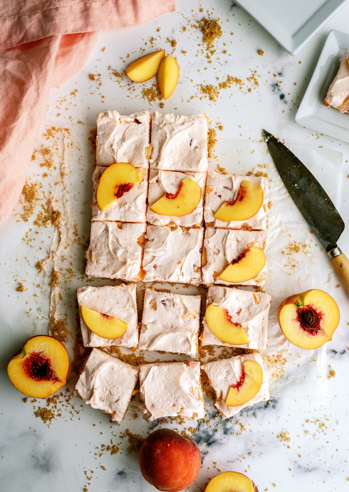 No-Bake Peach Cheesecake Bars cut into slices topped with fresh peaches