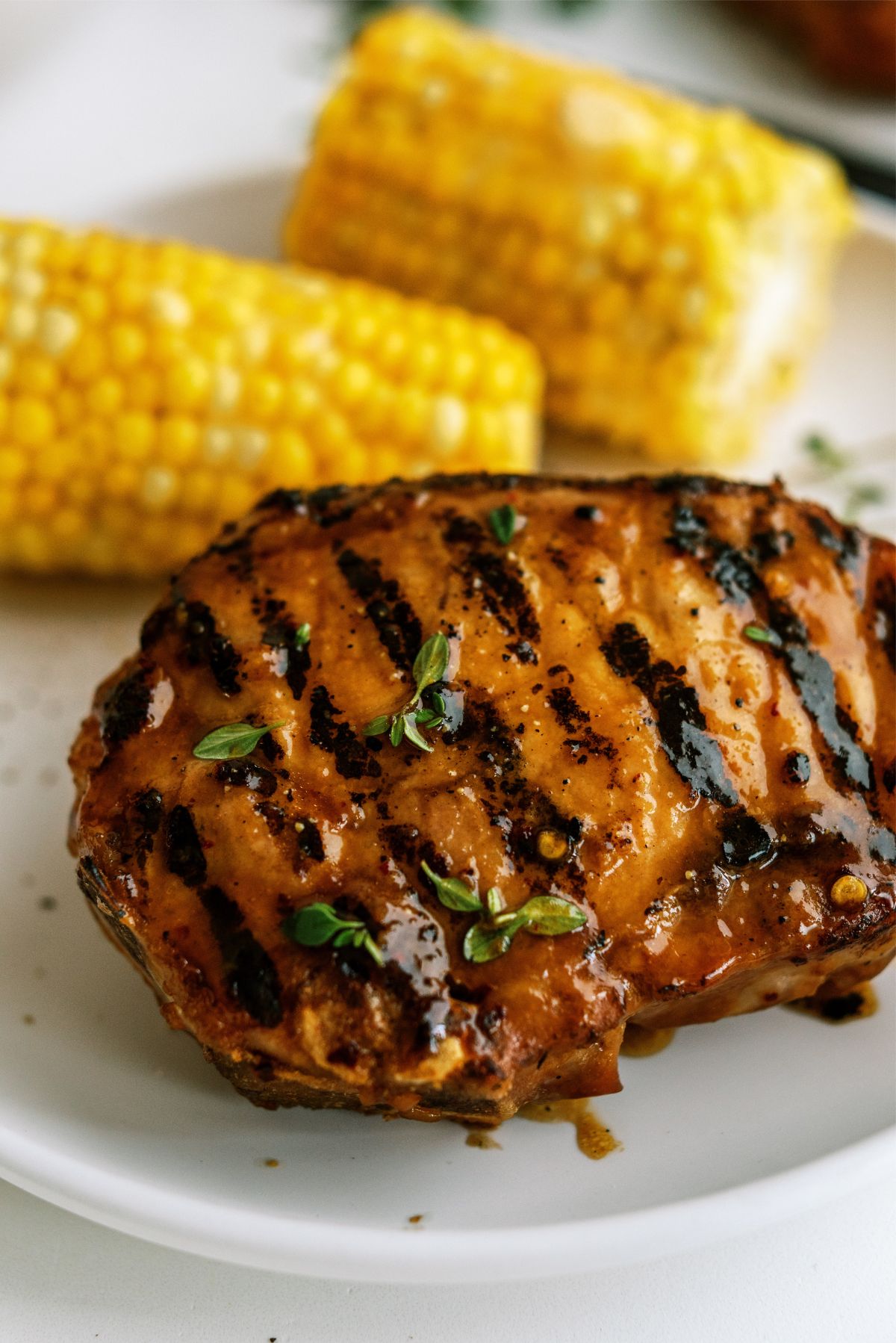 Perfectly Juicy Grilled Pork Chops on a plate with corn on the cob