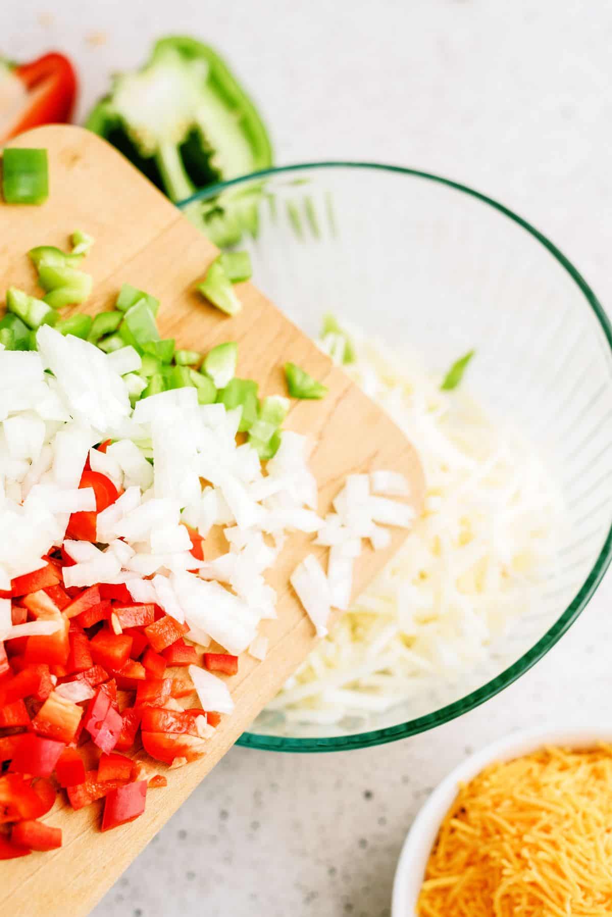 Diced peppers and onions added to a bowl