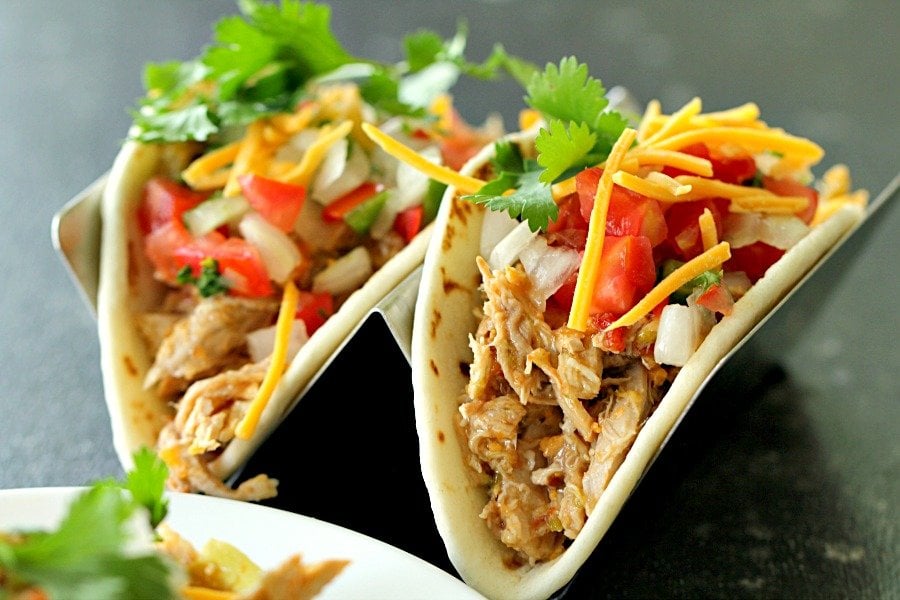 Two Slow Cooker Pork Chile Verde tacos in a taco holder