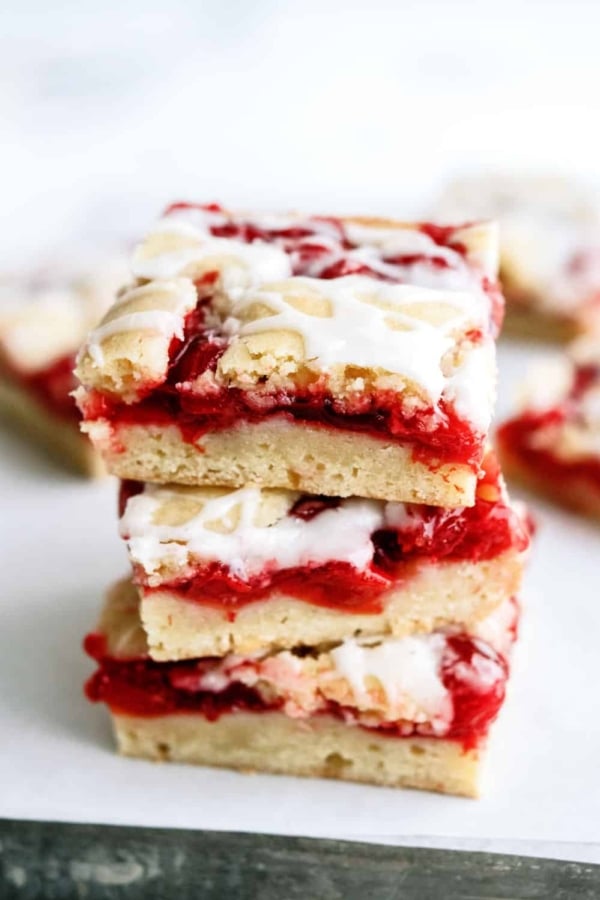 3 Cherry Pie Bars stacked on top of a white plate.