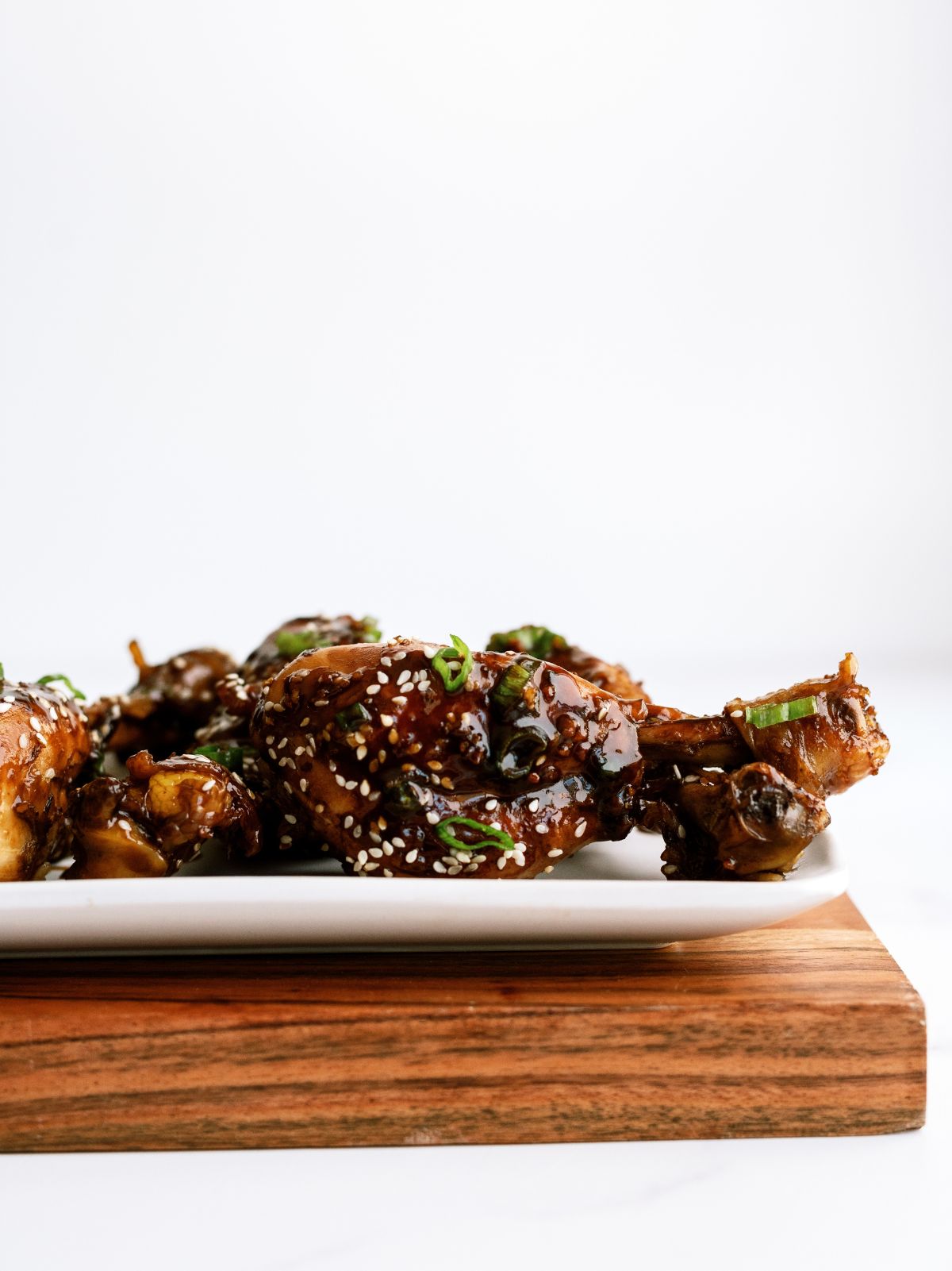 Side view of Asian Glazed Chicken Drumsticks on a plate