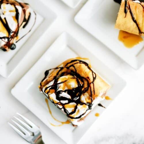 Top view of several plates with Cream Puff Cake Dessert slices on them and topped with chocolate drizzle.