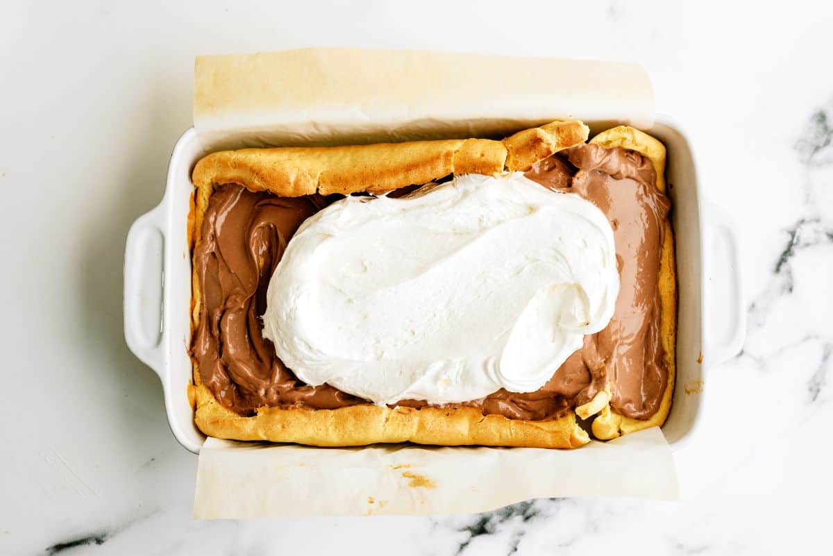 Layered pudding and whip cream over cream puff cake.