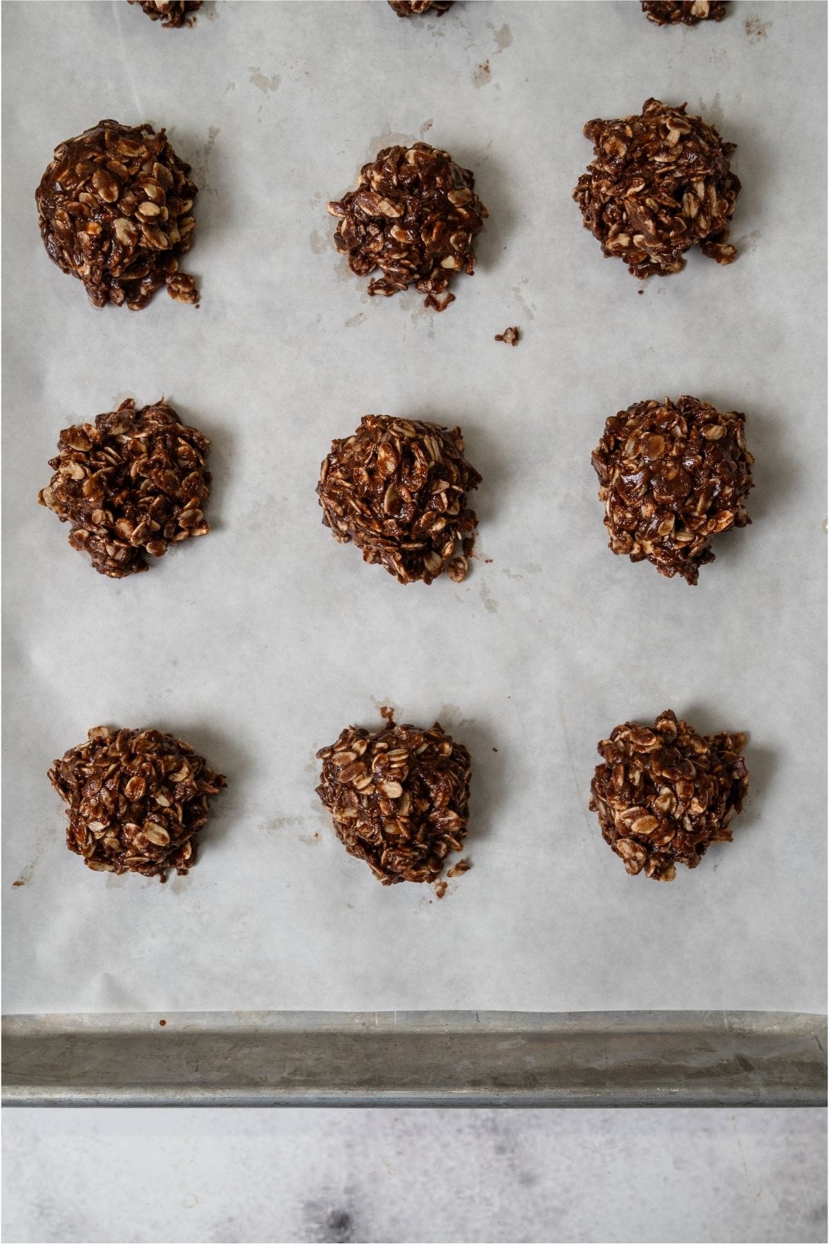 Healthier No Bake Chocolate Peanut Butter Cookies on a parchment lined baking sheet.
