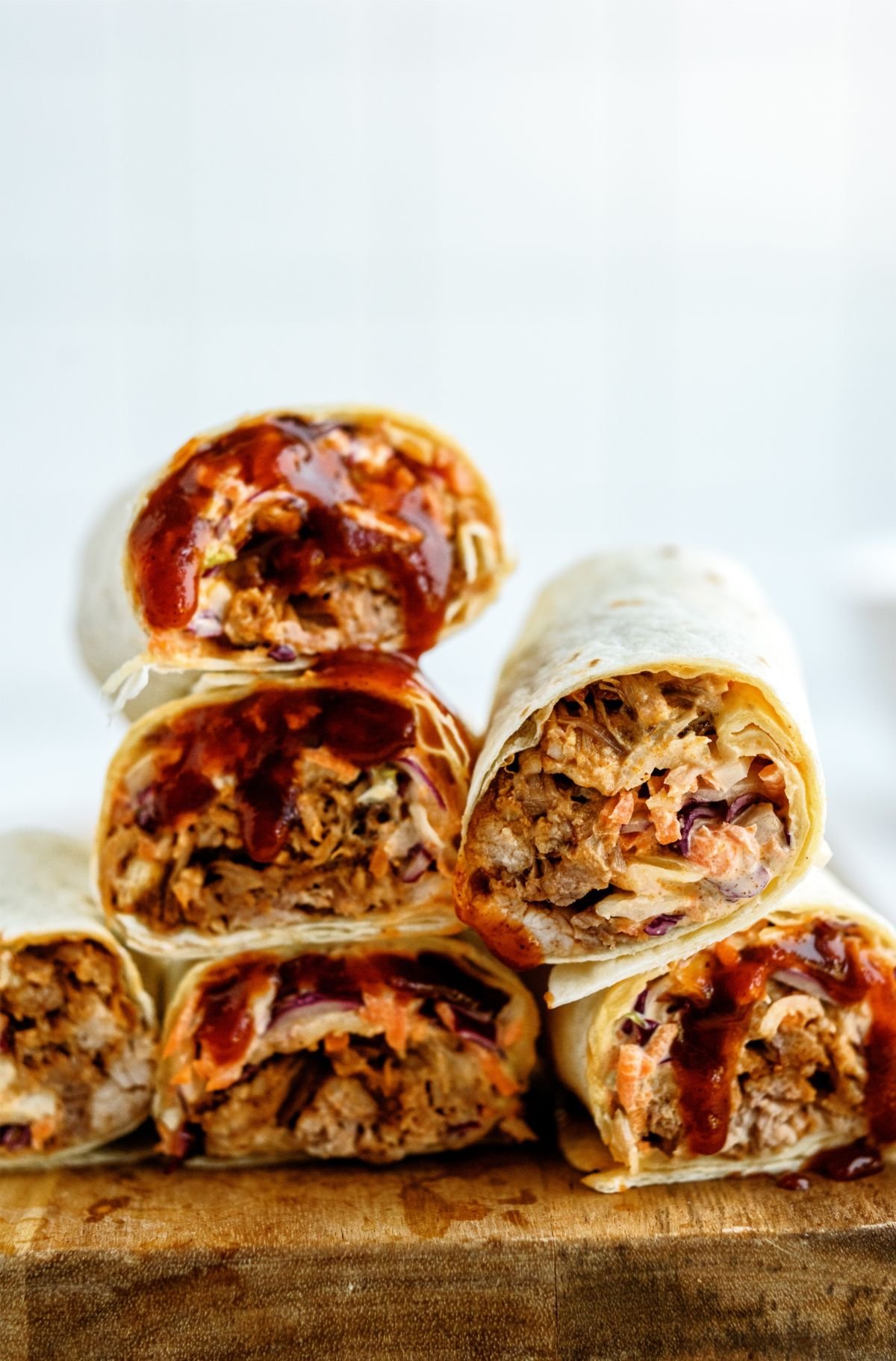 Instant Pot Honey BBQ Pork Wraps stacked on top of a cutting board