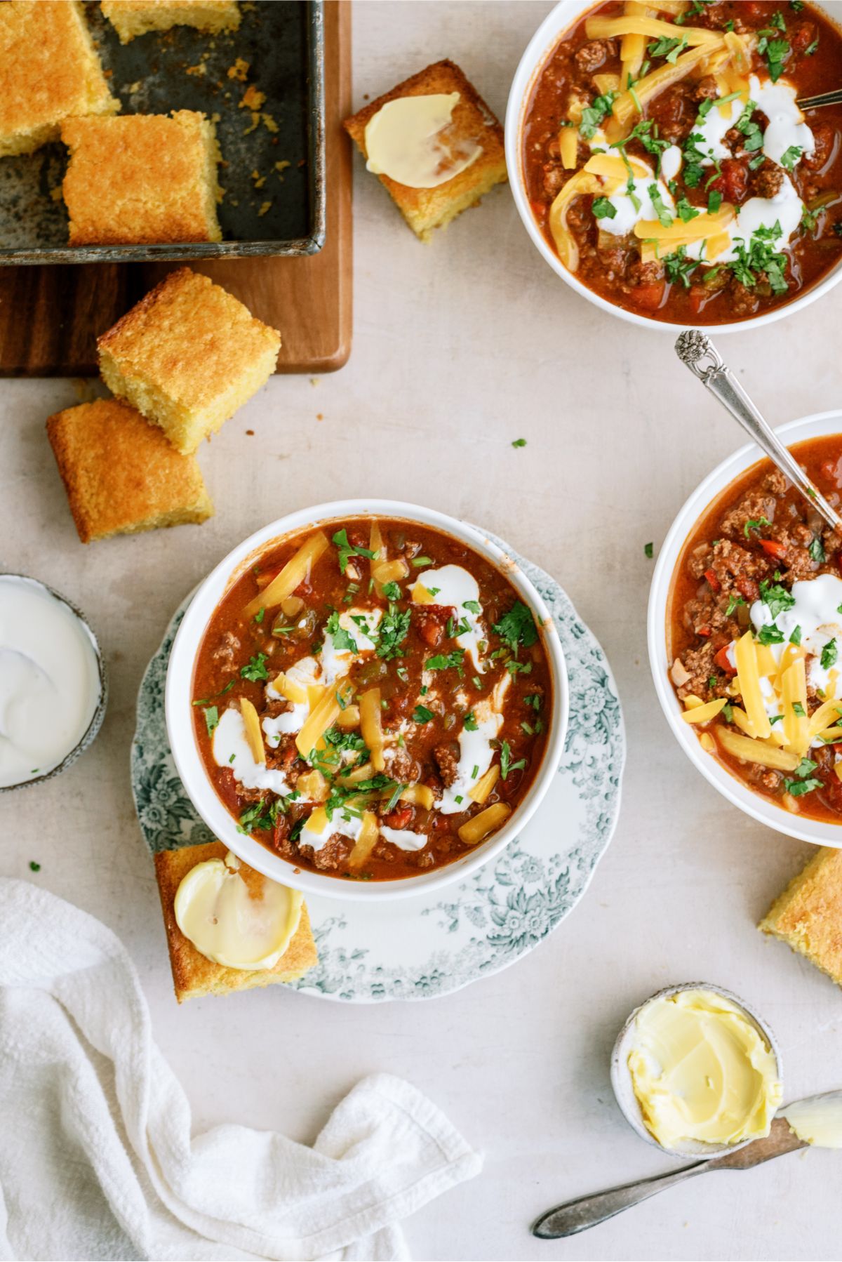 Top view of 3 bowls of Instant Pot No-Bean Chili with Ground Beef with corn bread