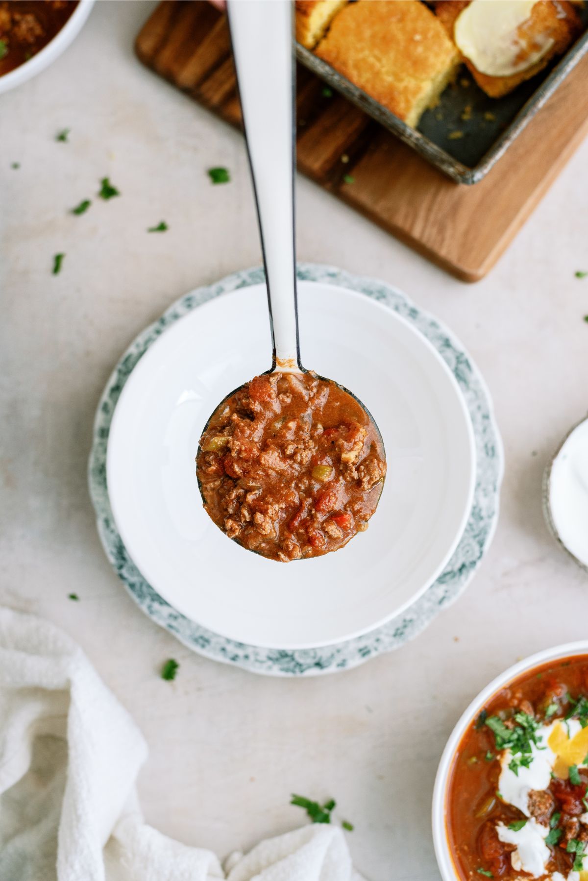 A scoop of Instant Pot No-Bean Chili with Ground Beef going into a bowl