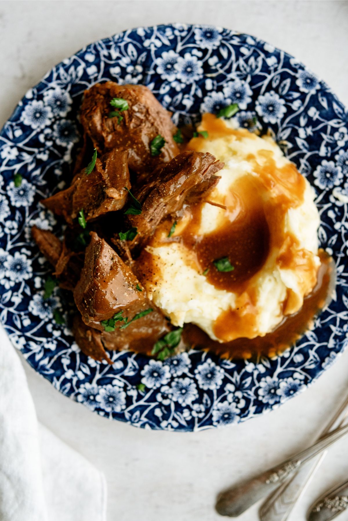 Top view of Instant Pot Texas Roadhouse Pot Roast and mashed potatoes with gravy on a plate