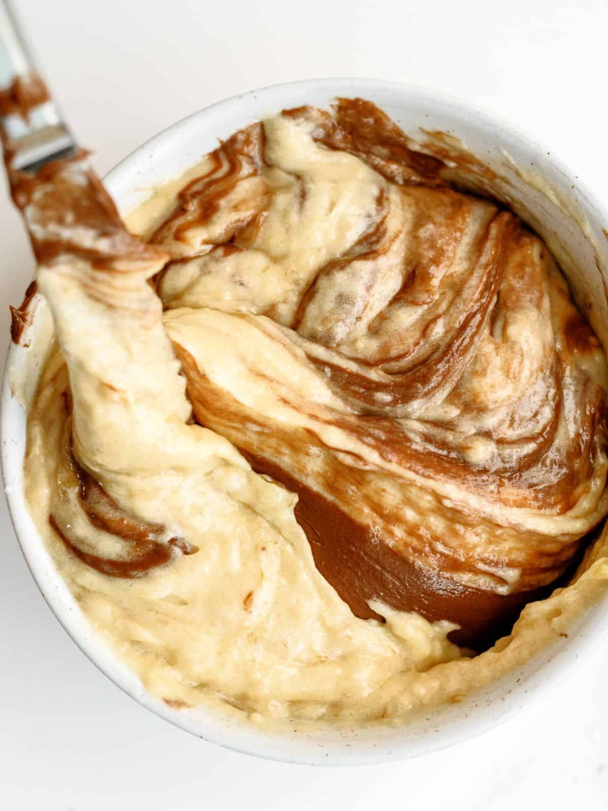 Adding nutella to banana bread mixture in mixing bowl