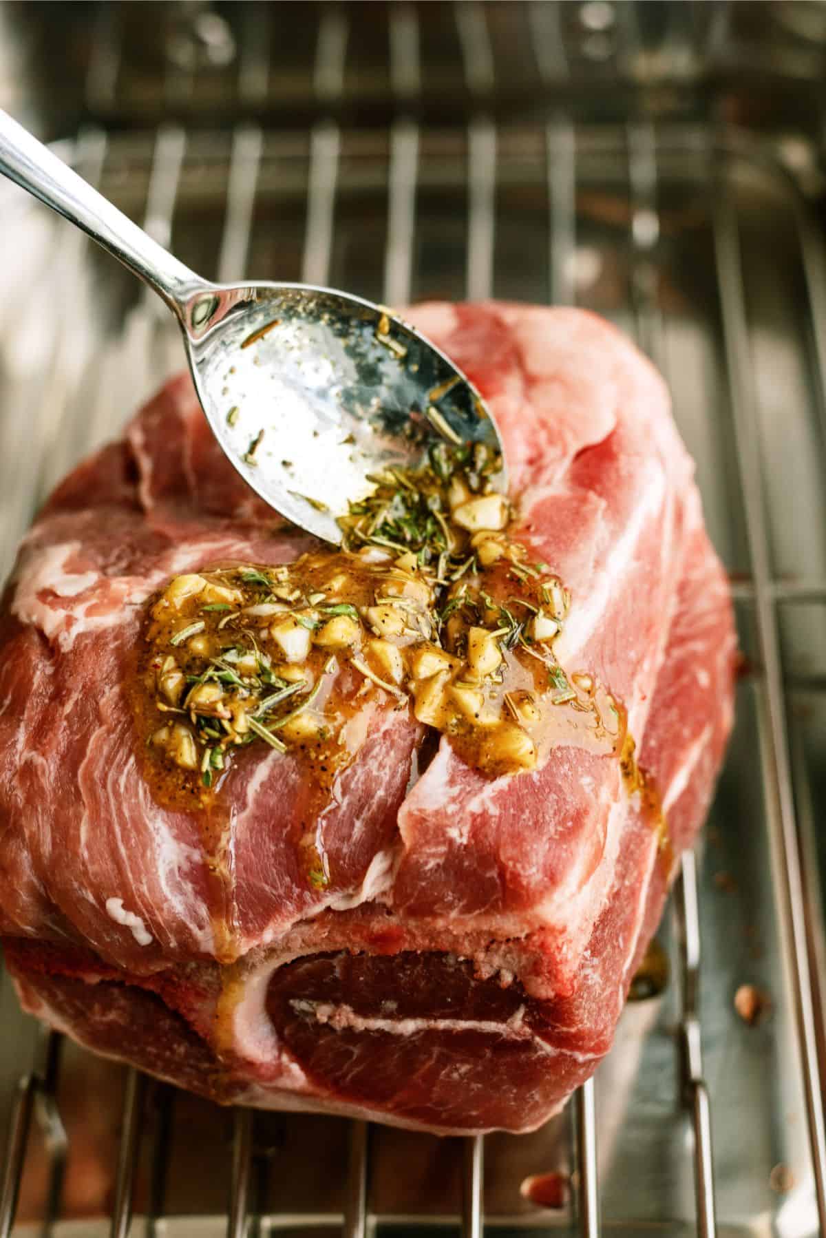 Spreading seasoning mixture on roast in pan