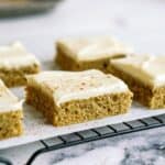 Sheet Pan Zucchini Cake with Frosting sliced into squares.