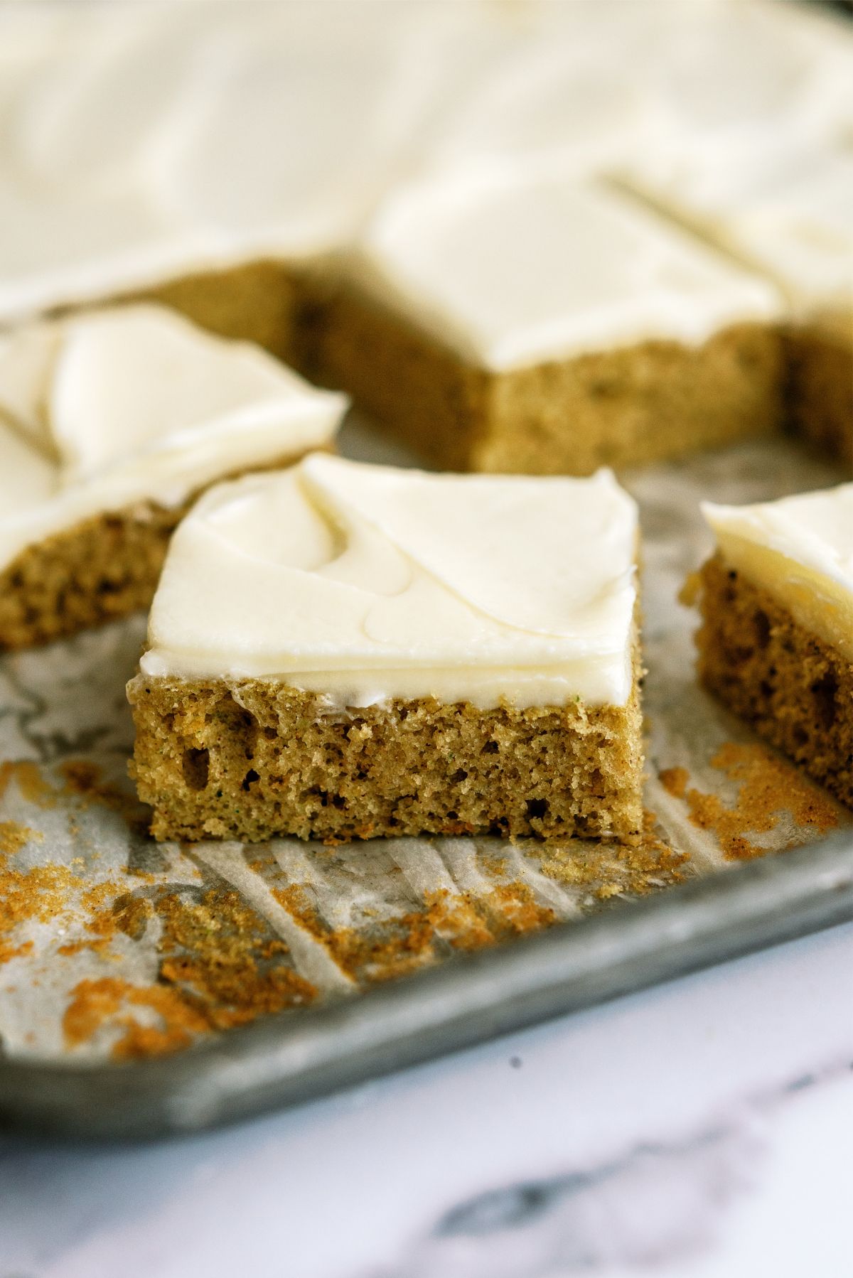 Sheet Pan Zucchini Cake with Frosting cut into squares