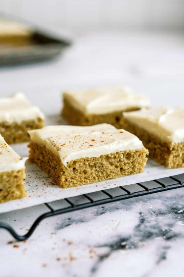 Sheet Pan Zucchini Cake with Frosting sliced into squares.