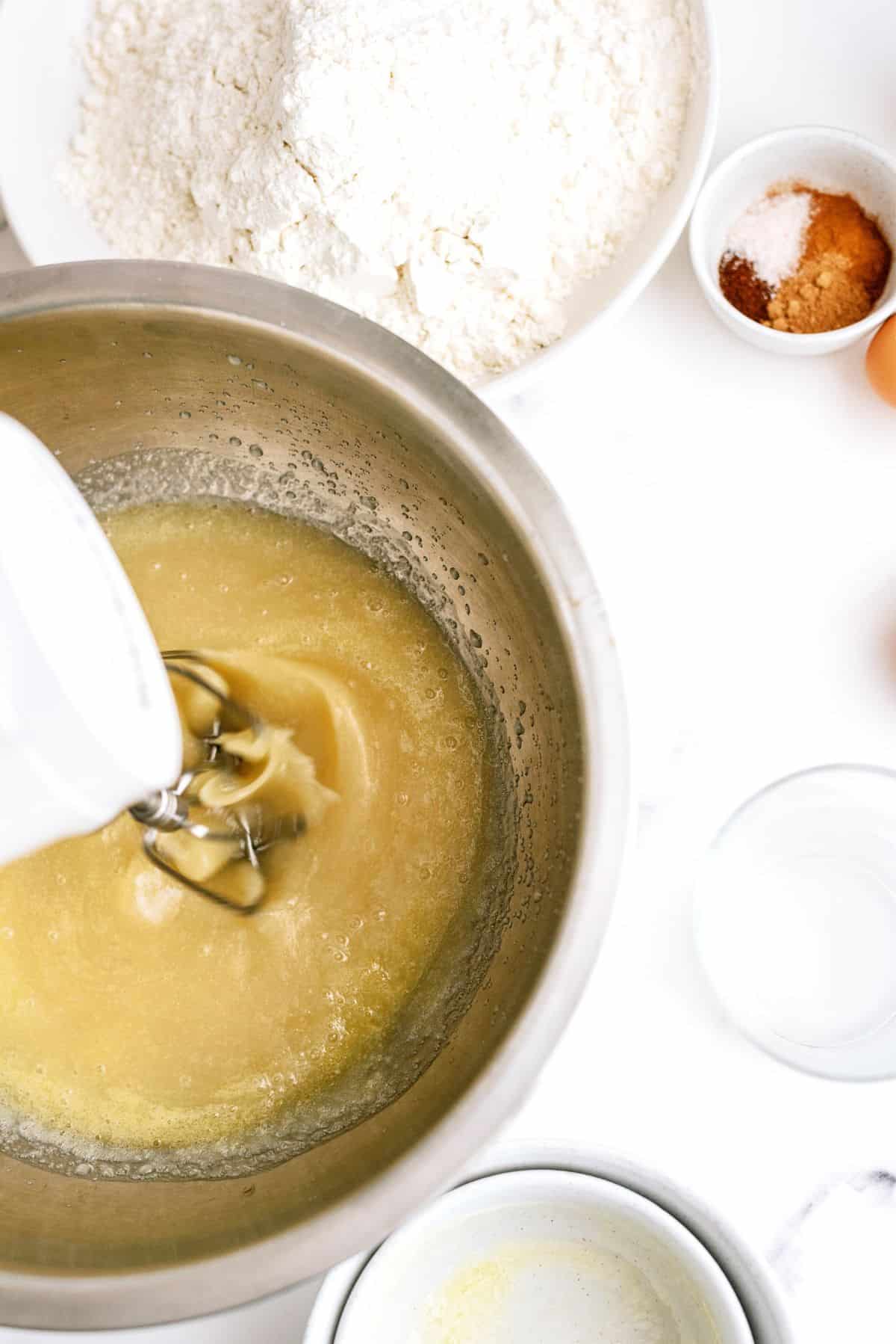 Mixing ingredients for cake batter with a hand mixer.