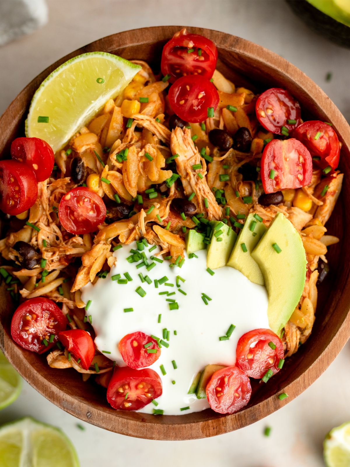 Slow Cooker Chicken Enchilada Pasta in a bowl with toppings