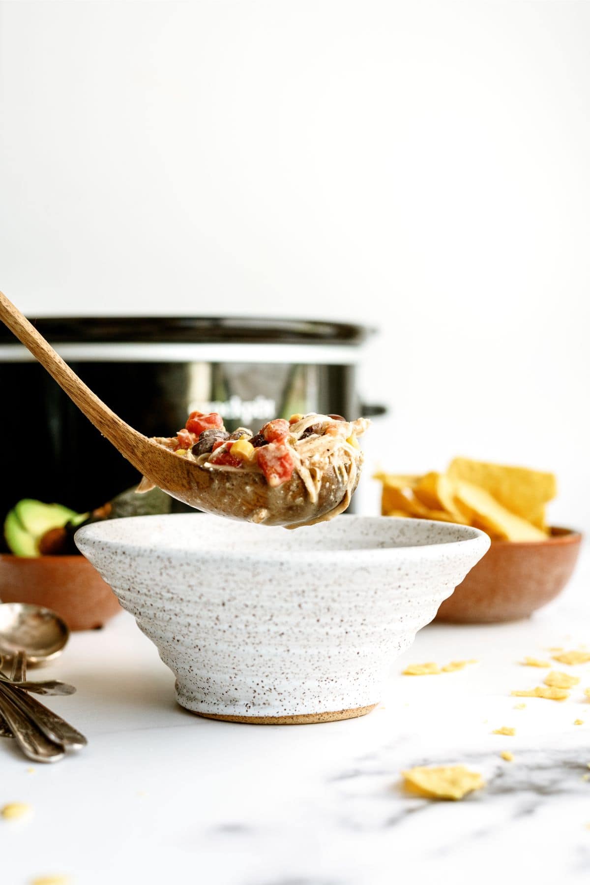 Spooning a serving of Slow Cooker Cream Cheese Chili into a bowl