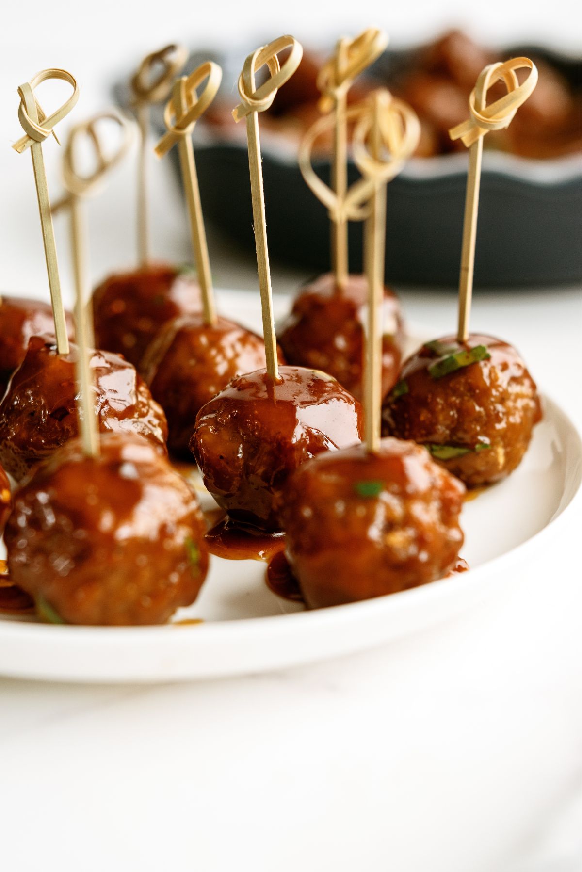 Slow Cooker Honey Buffalo Meatballs on a serving plate with toothpicks