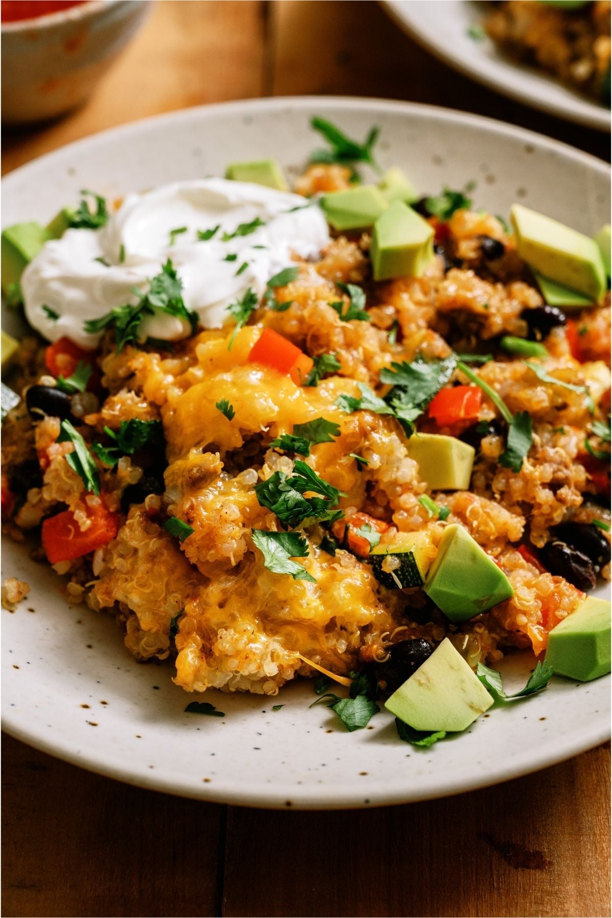 A serving of Zucchini Taco Casserole on a plate topped with sour cream.