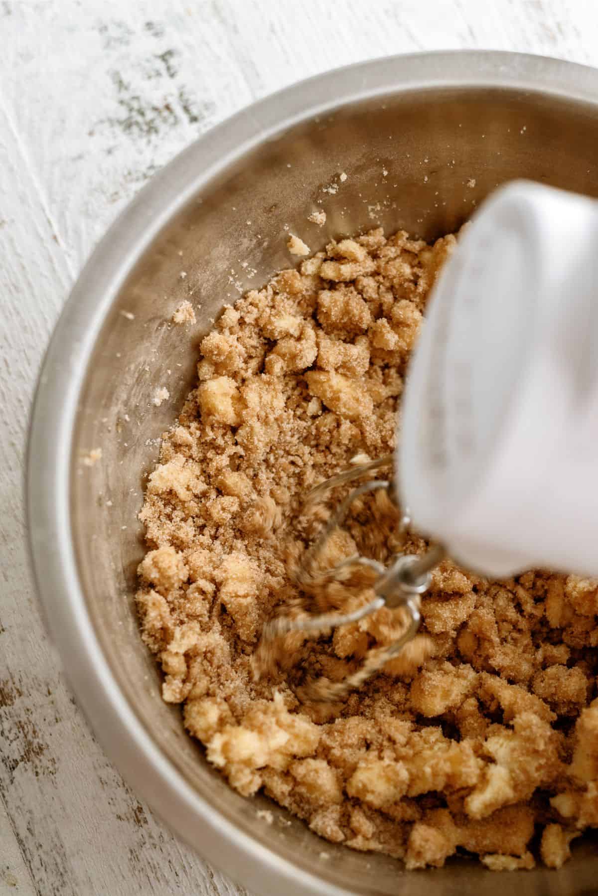 Ingredients for cookie dough mixed together with hand mixer in a bowl