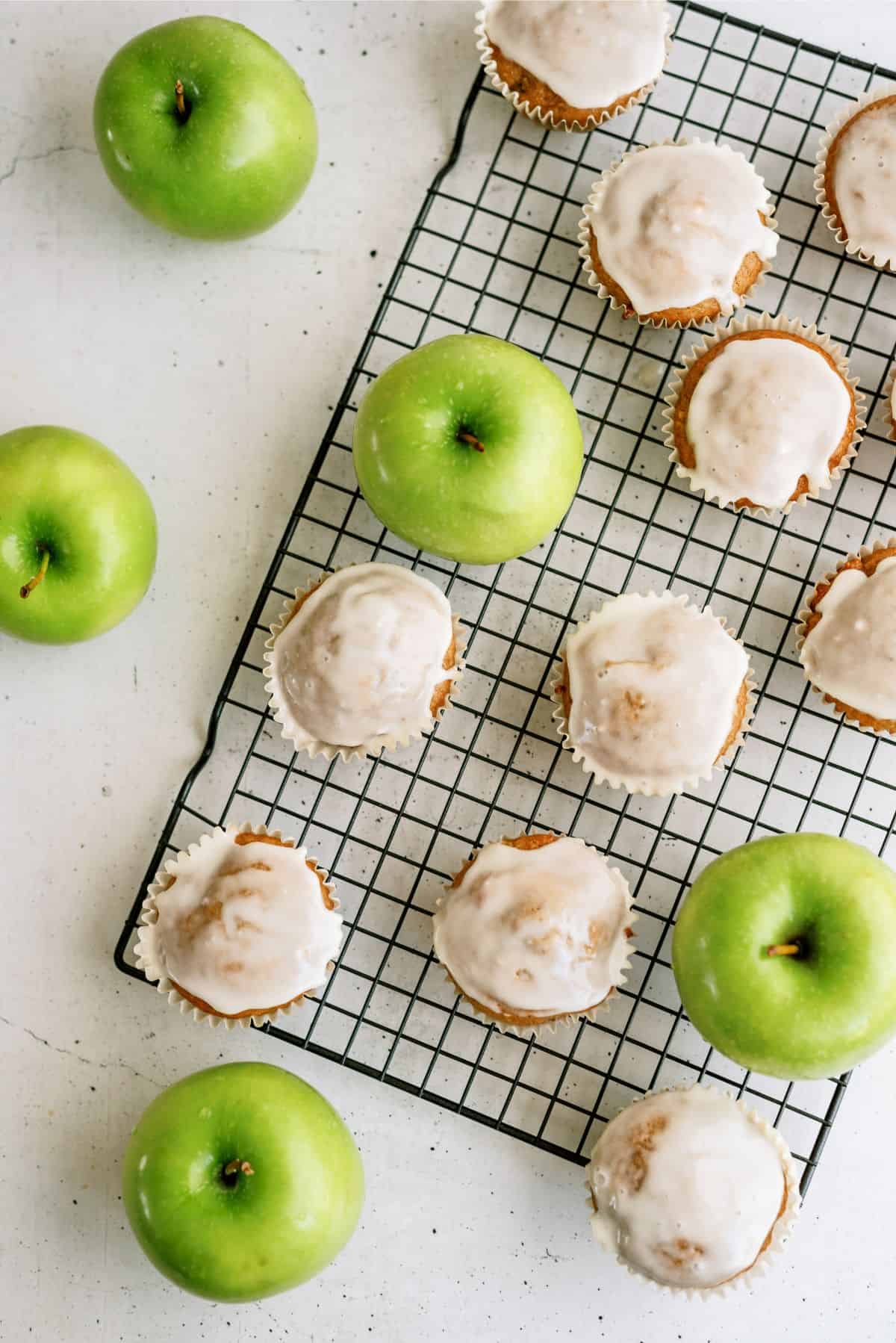 Baked Apple Fritter Muffins frosted on a cooling rack