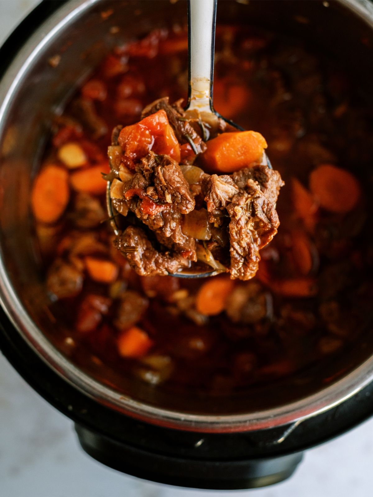 A scoop of Instant Pot Beef Daube Stew  in a ladle