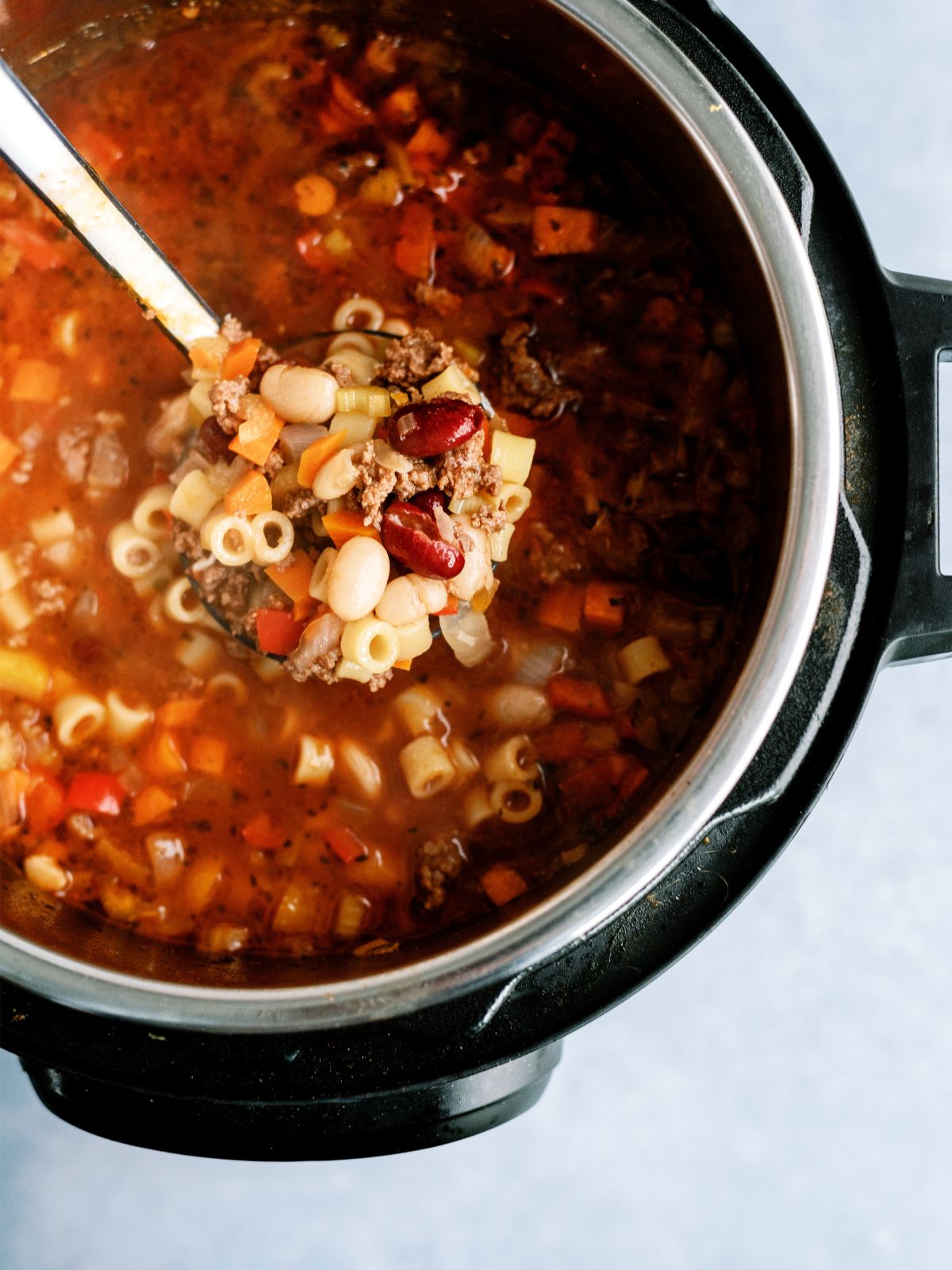 Instant Pot filled with Instant Pot Pasta e Fagioli Recipe (Olive Garden Copycat) with a ladle 