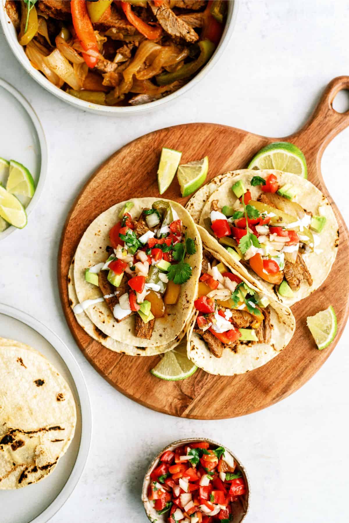 Instant Pot Steak Fajitas on a cutting board with toppings